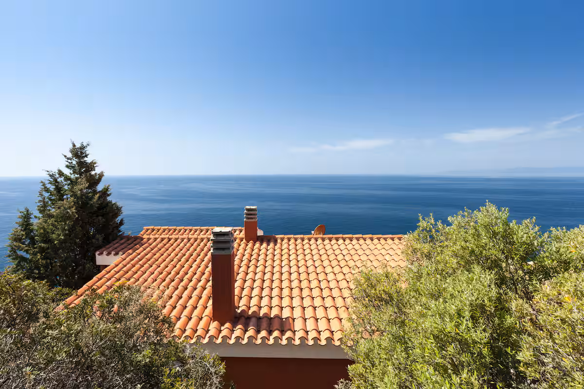 Terracotta rooftops framed by the blue sea