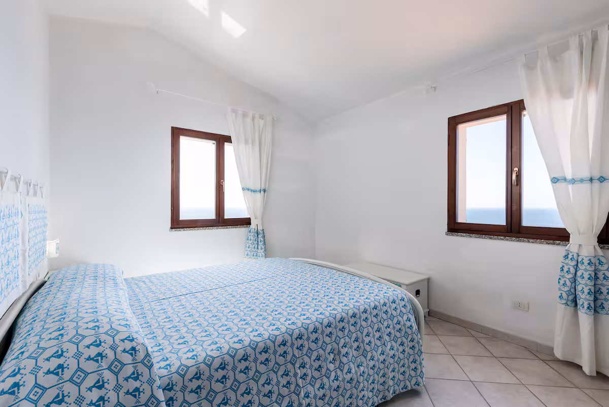 The master room with its Sardinian-patterned double bed and sea-view windows