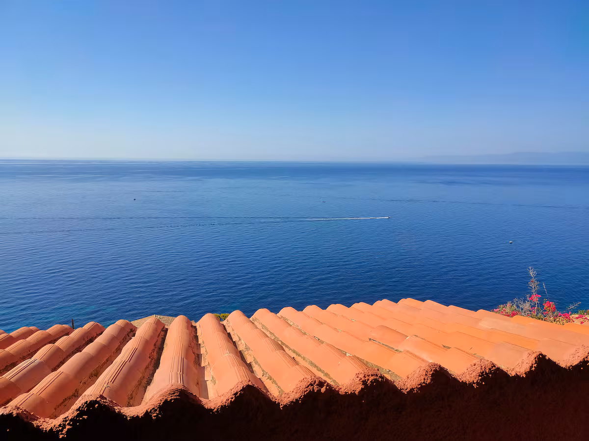 Terracotta rooftops and the endless blue in front of the villa